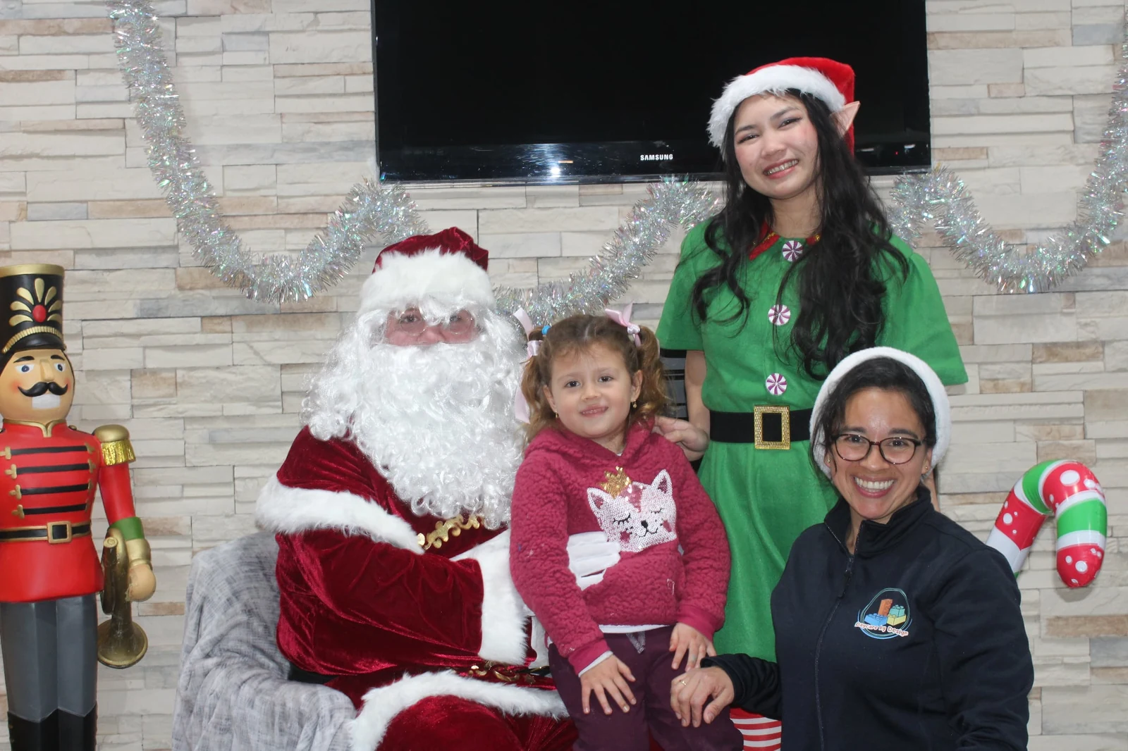 Santa and a holiday elf sharing a festive family moment